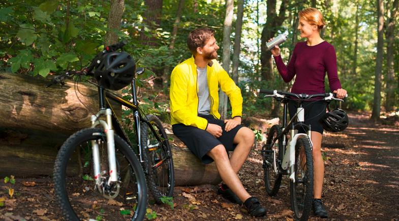 Paar rastet mit ihren Fahrrädern im Wald